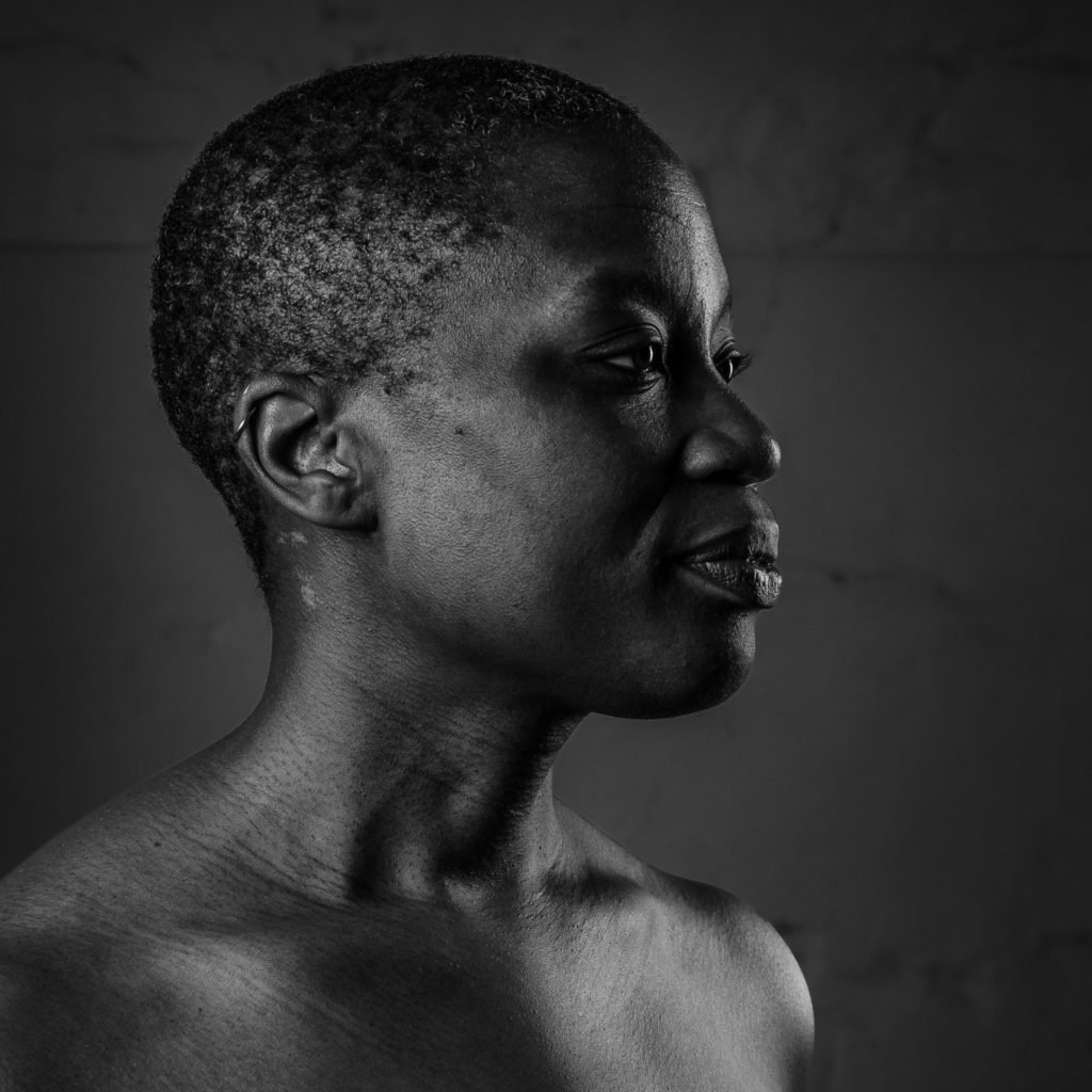 Black and white profile portrait of a Caritia, a Black person looking to the right.