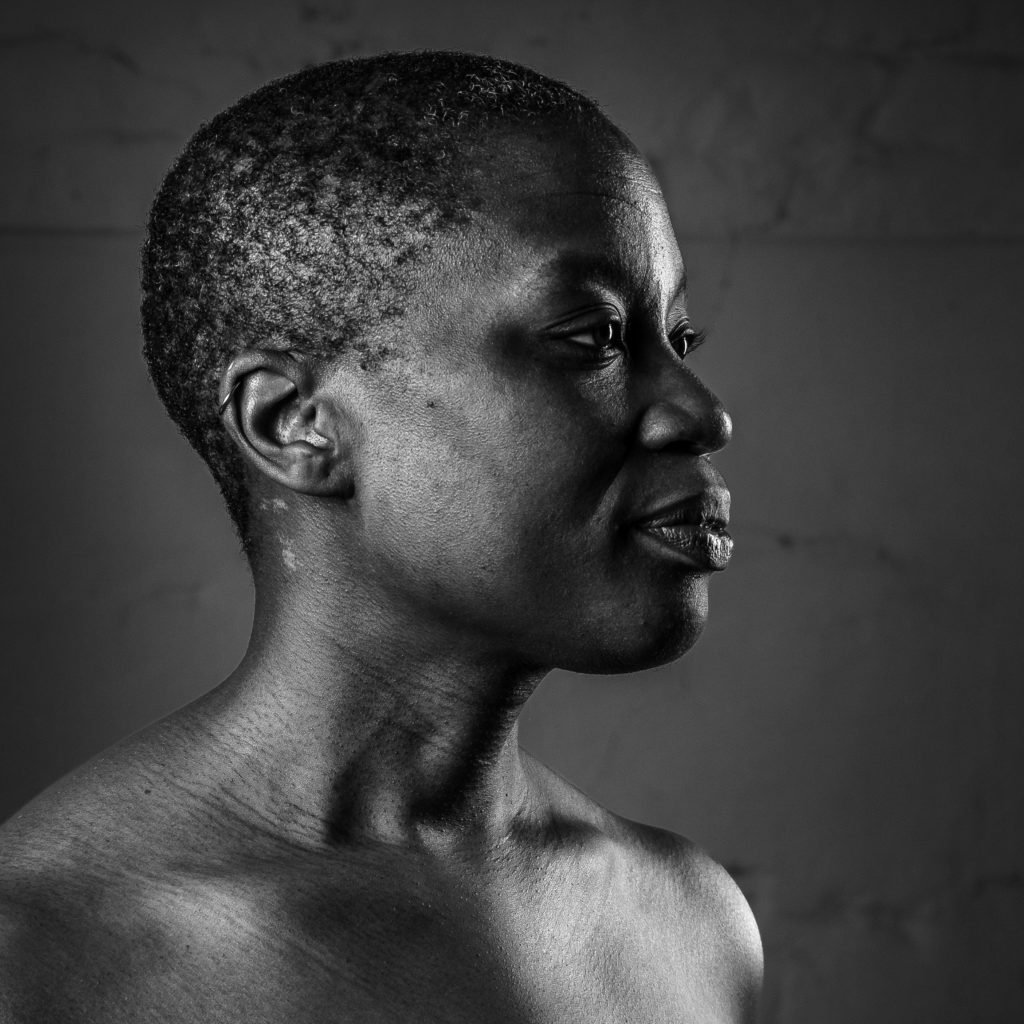Black and white profile portrait of a Caritia, a Black person looking to the right.