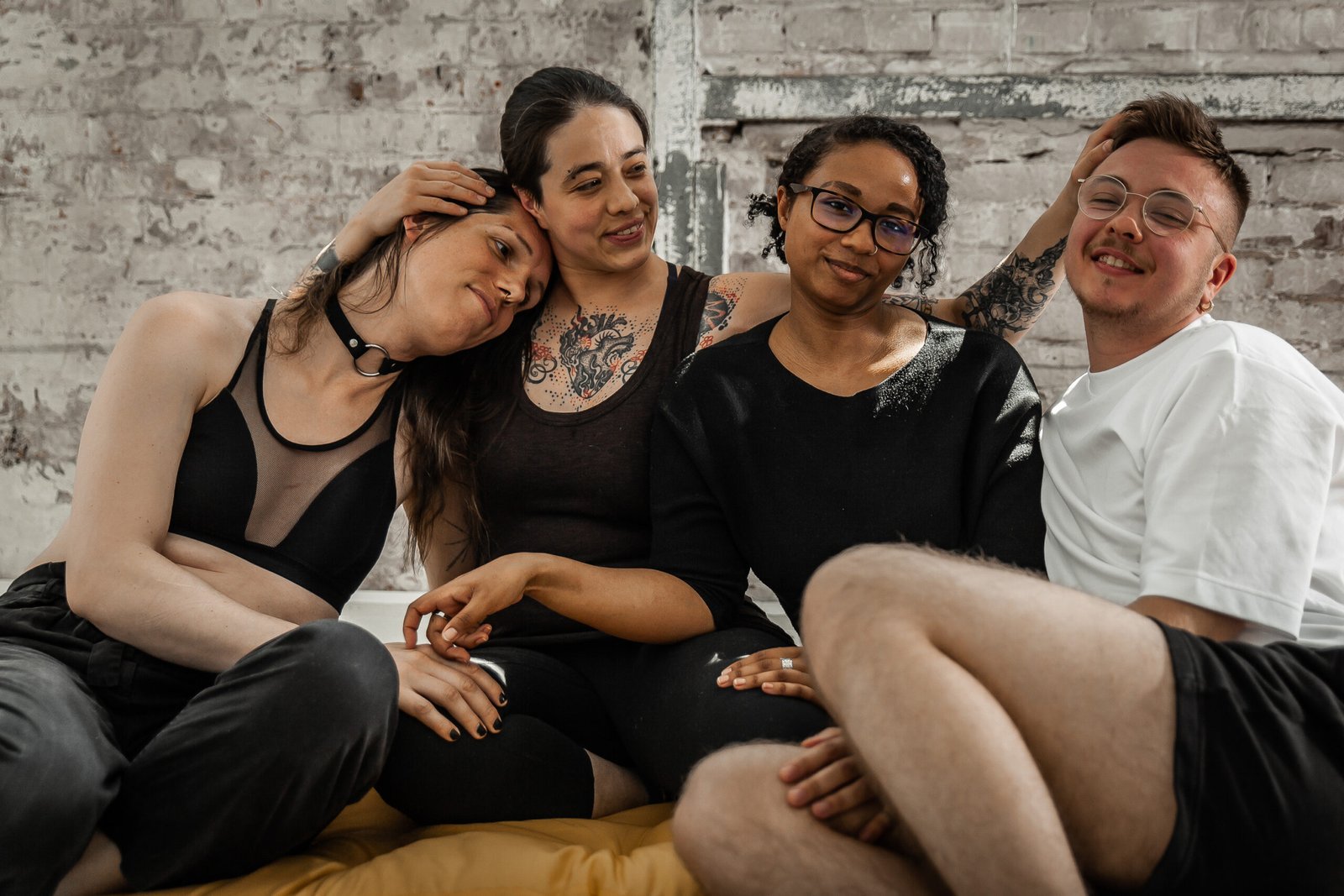 Group of friends sitting together, smiling indoors.