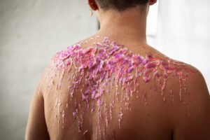 Pink and orange wax on the back of a white person. This is temperature and sensation play.