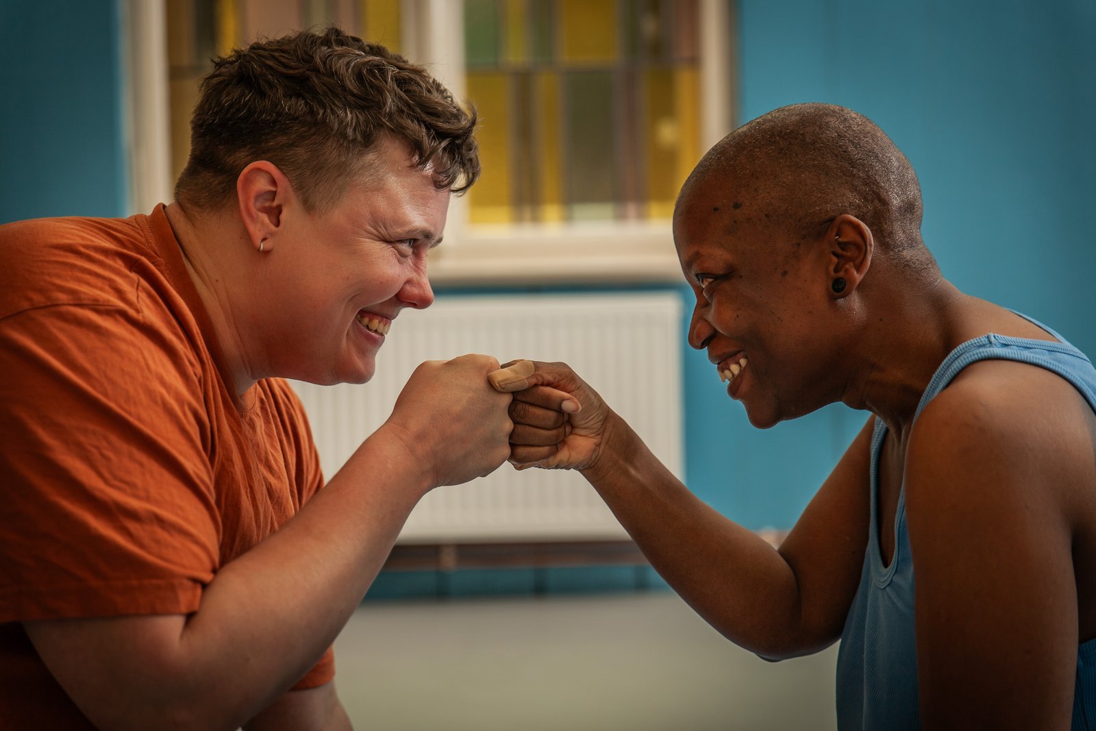 Two queer people fist bumping