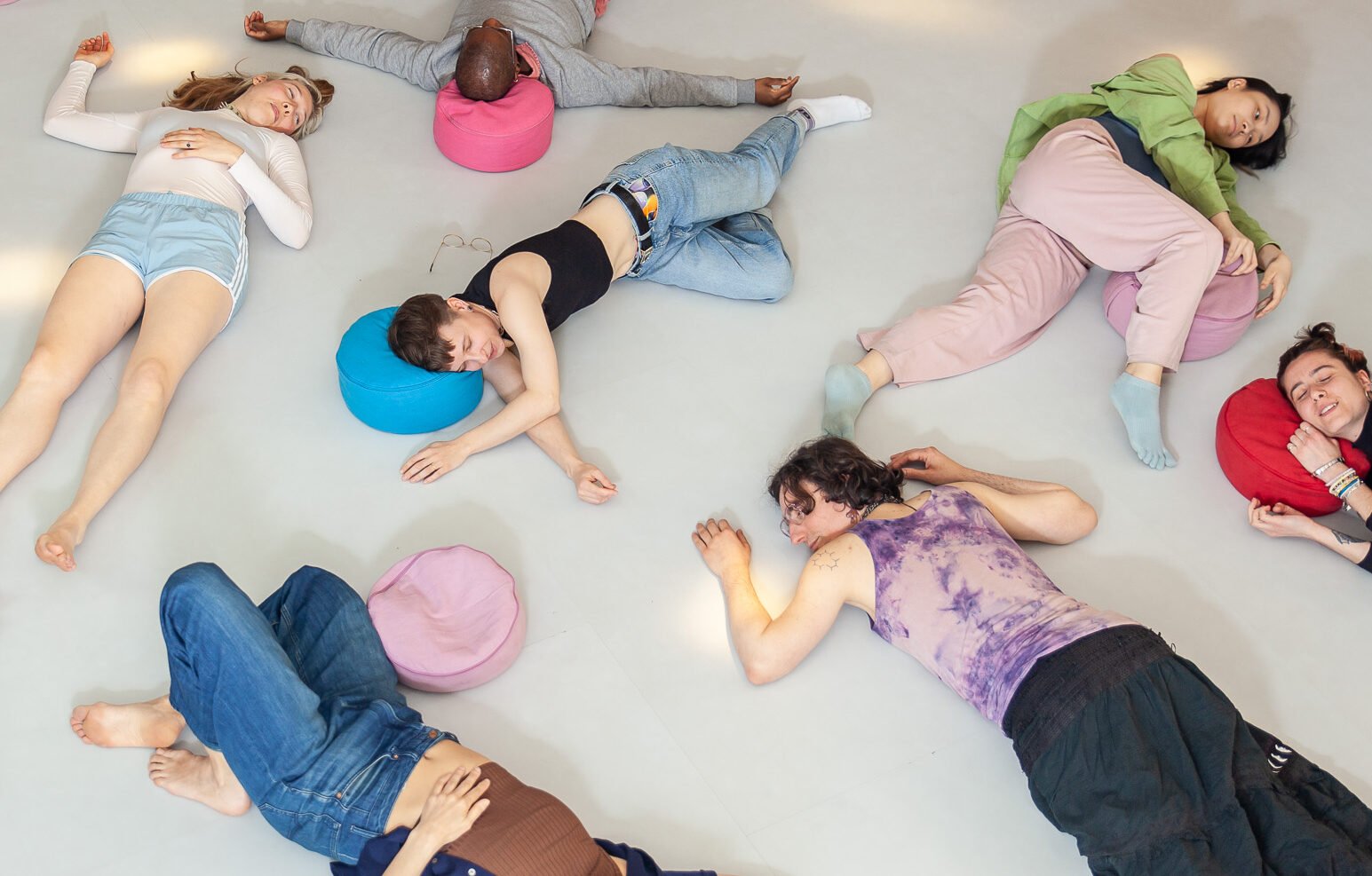 Group of people relaxing on floor with cushions.