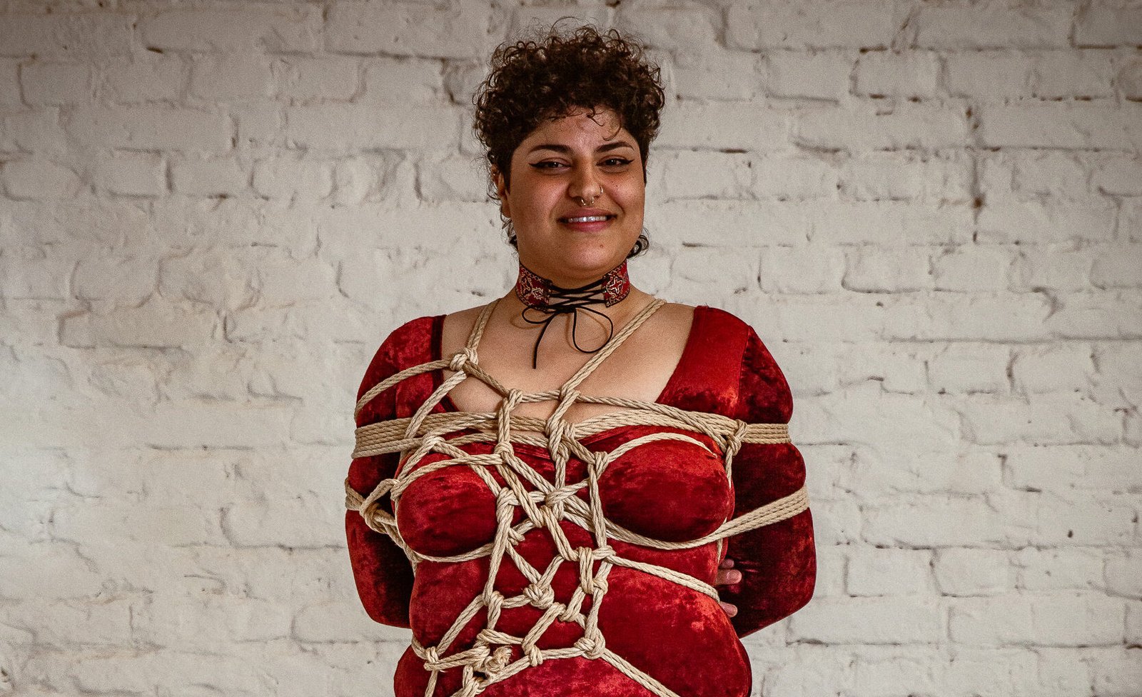 Person in red outfit with rope harness.