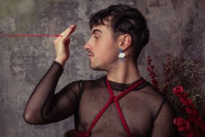 Person with red string, artistic expression.