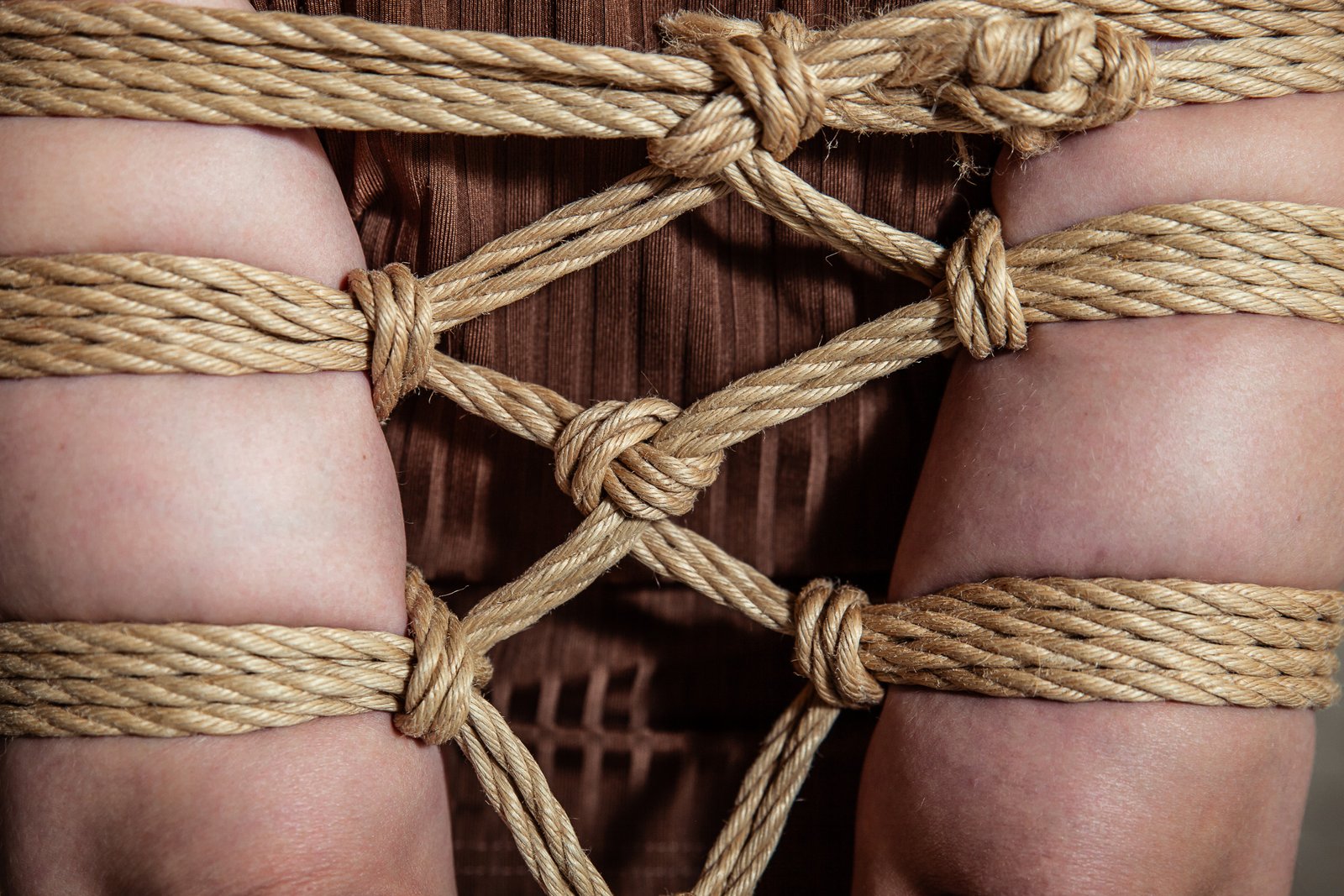 Close-up of intricate rope knots on legs.