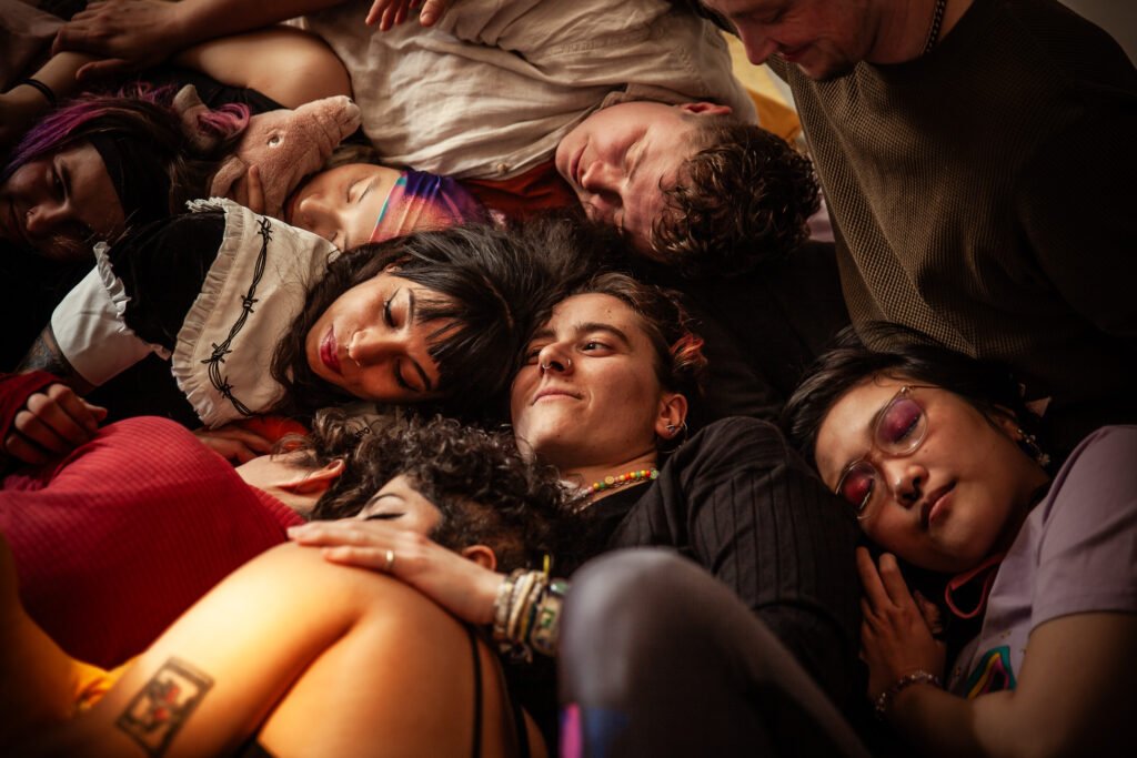 A group of queer people in a big and cozy cuddle puddle