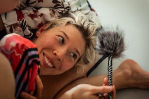 Smiling person holding a fluffy object indoors.