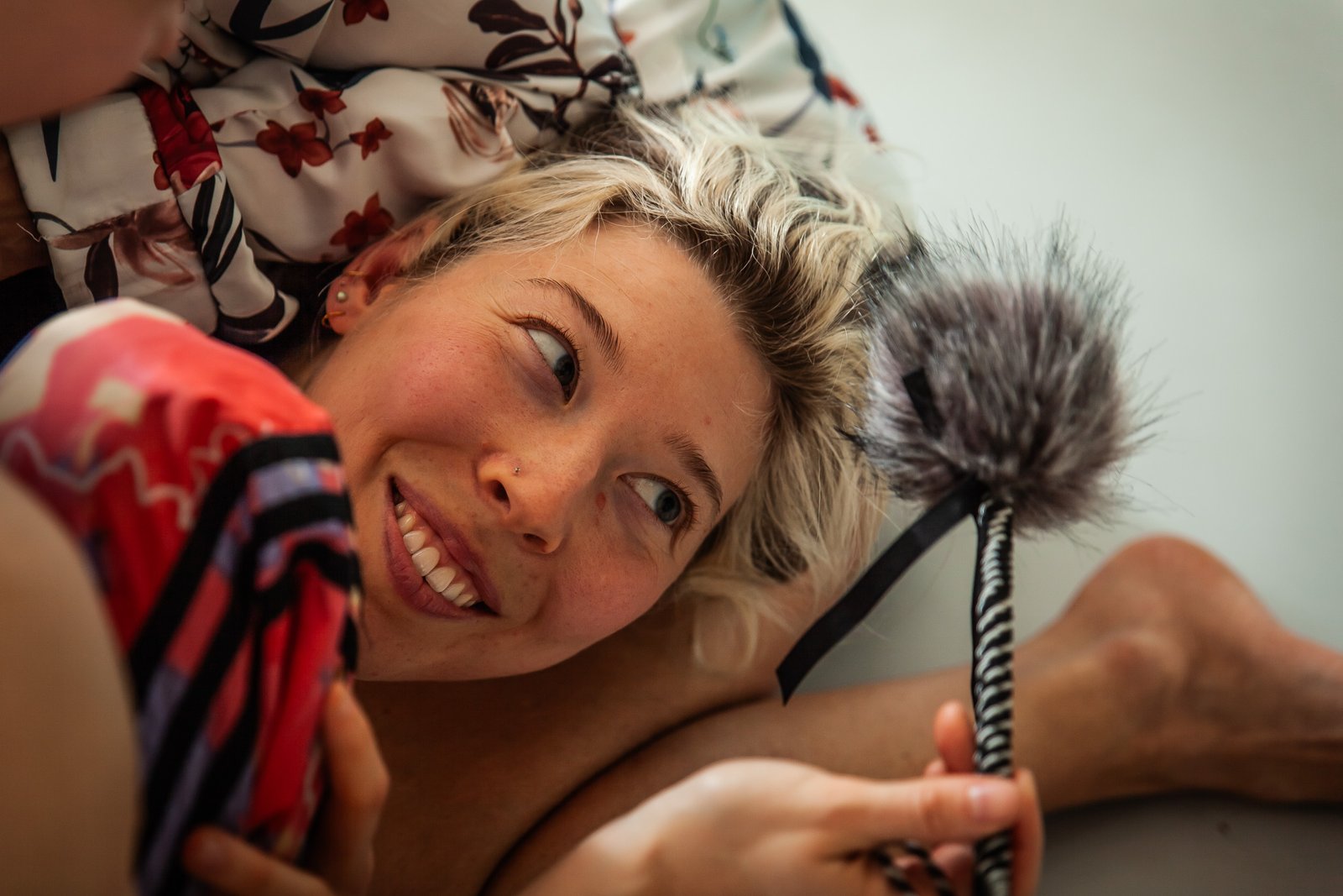 Smiling person holding a fluffy object indoors.