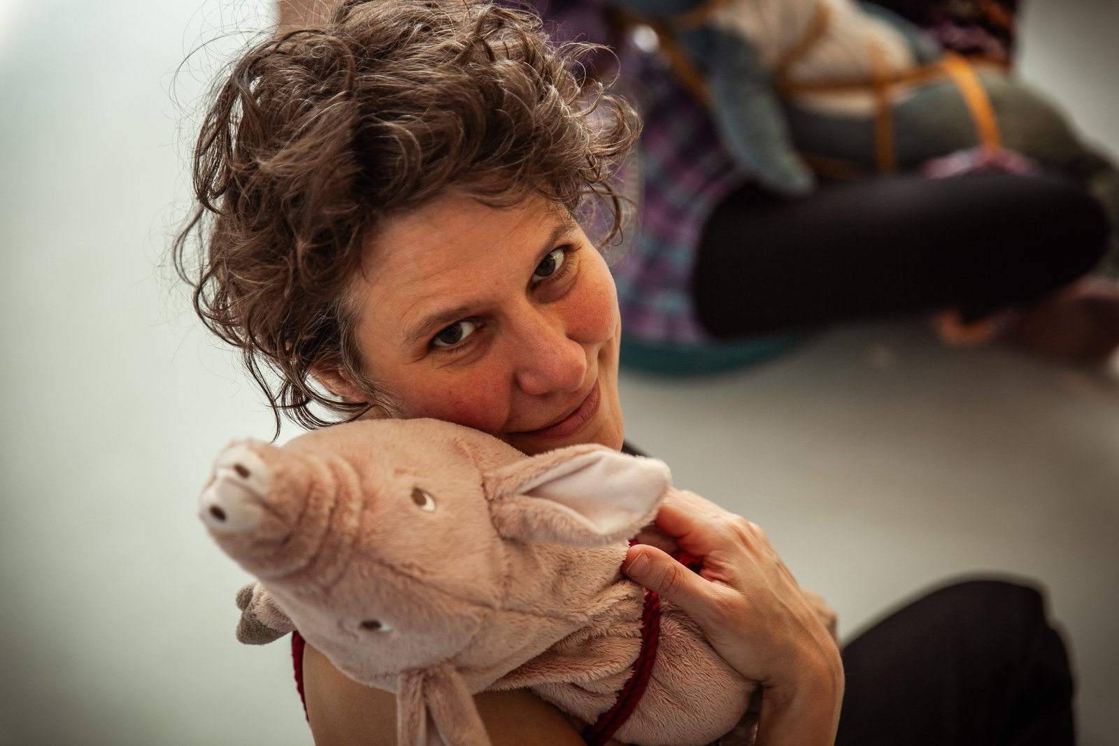 mg 5708 Person hugging a pig plush toy, smiling warmly.