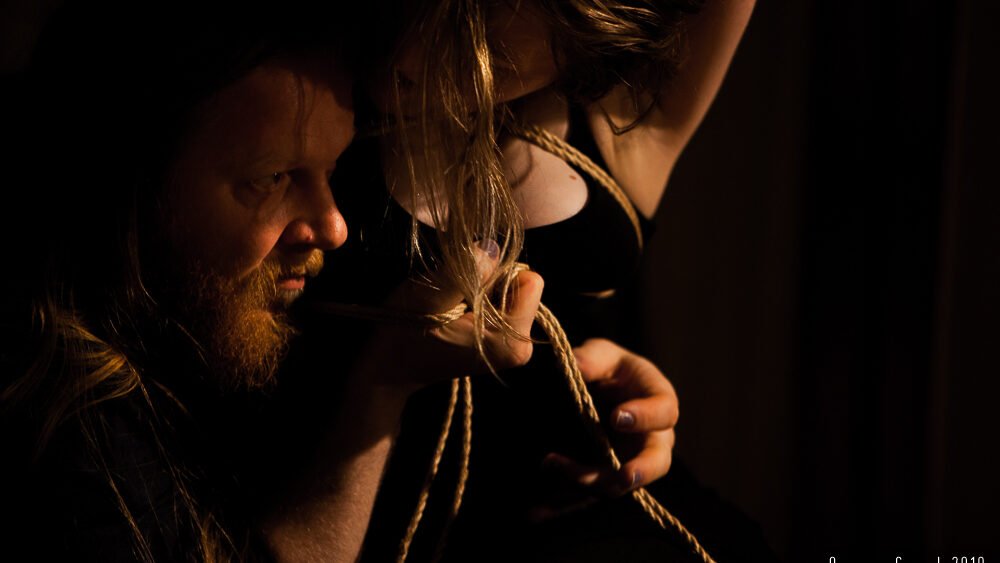 Man holding rope in dark room