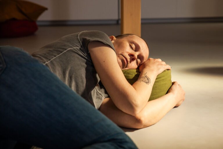 Person sleeping peacefully on the floor with pillow
