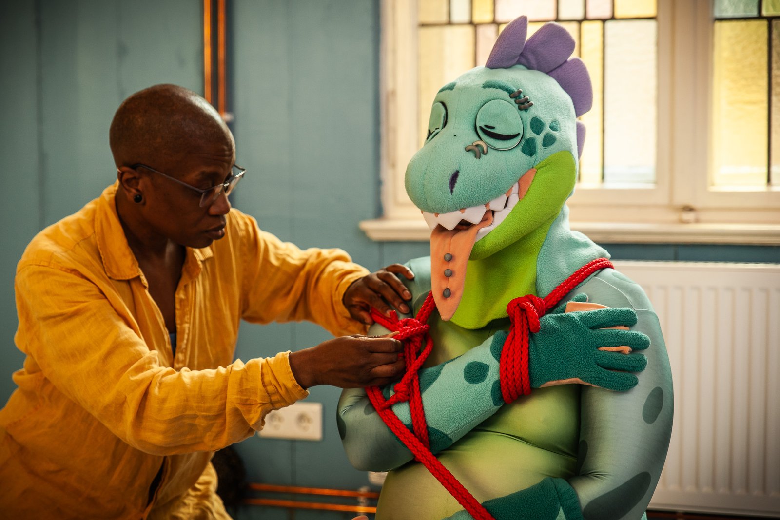 Person ties ropes around costumed character