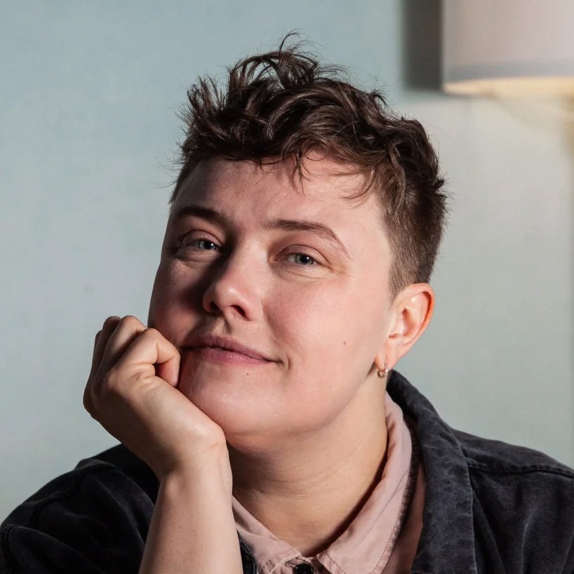 Person smiling with hand on chin.