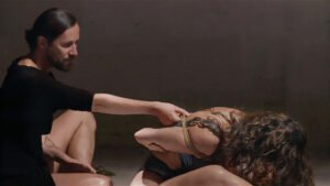 Man ties woman's arms with rope in performance