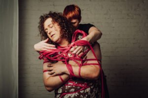 Two people in rope bondage embrace passionately.