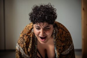 Person expressing surprise or excitement indoors.