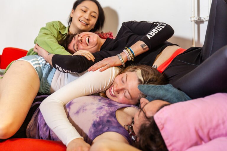 Four friends in a playful group hug