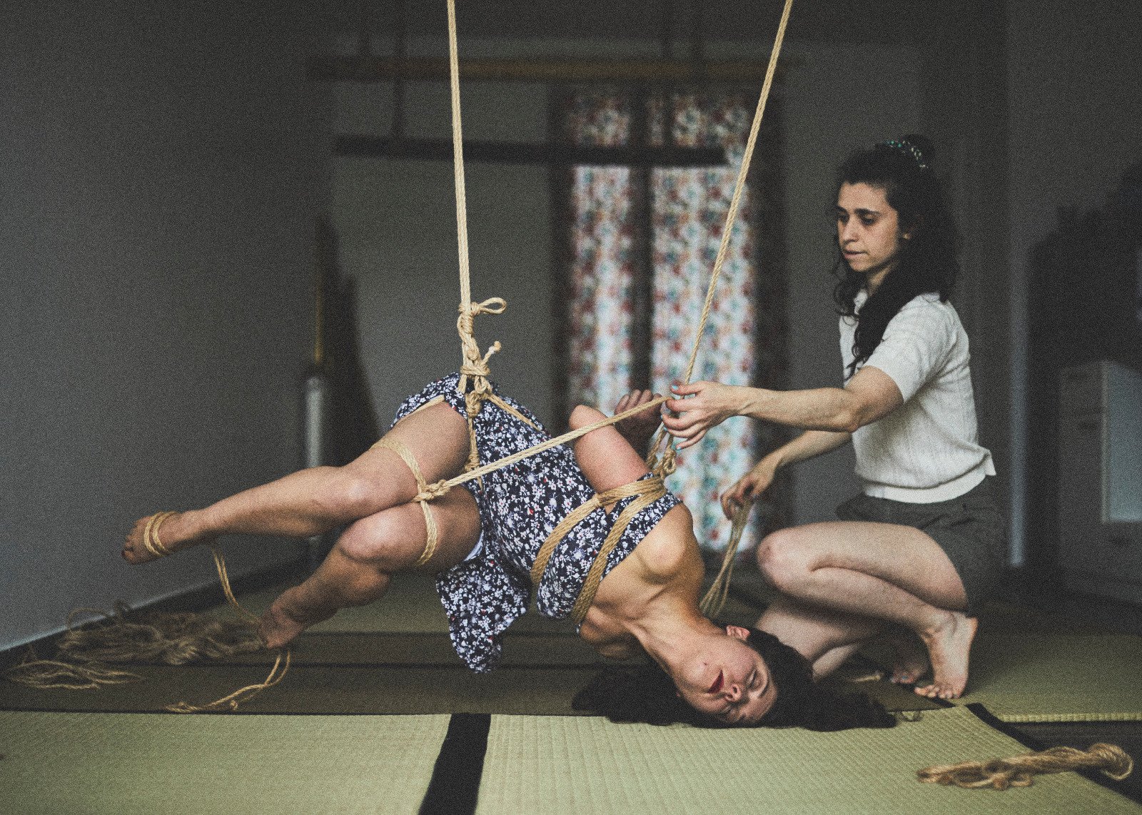 Artistic rope suspension in dimly lit room.