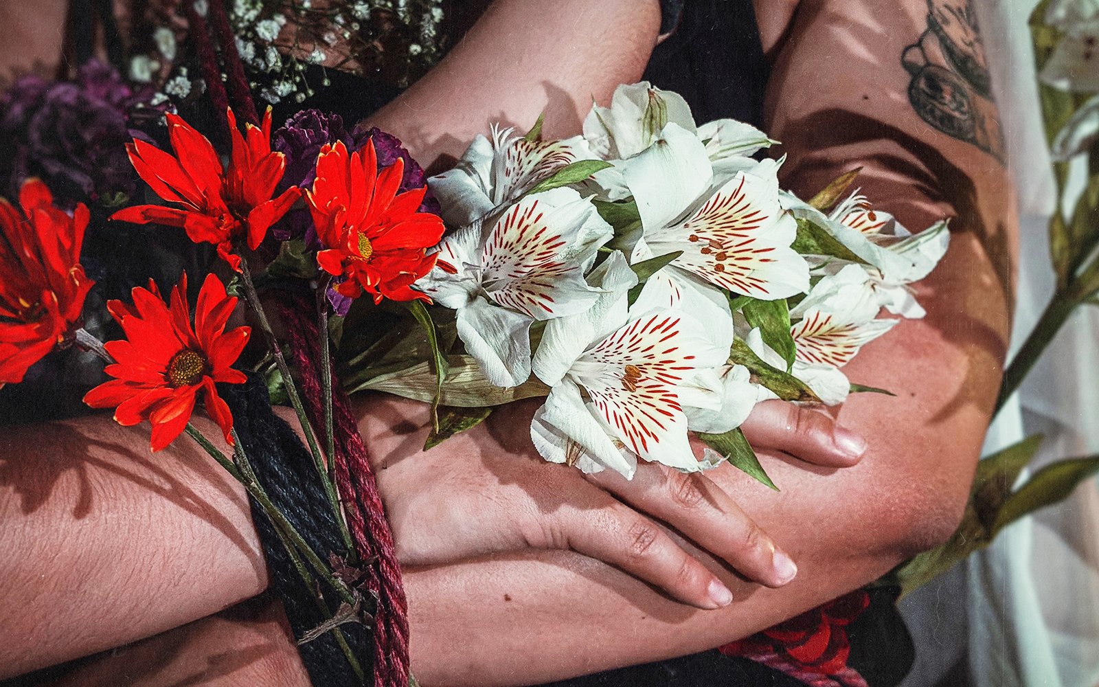 Person holding red and white flower bouquet