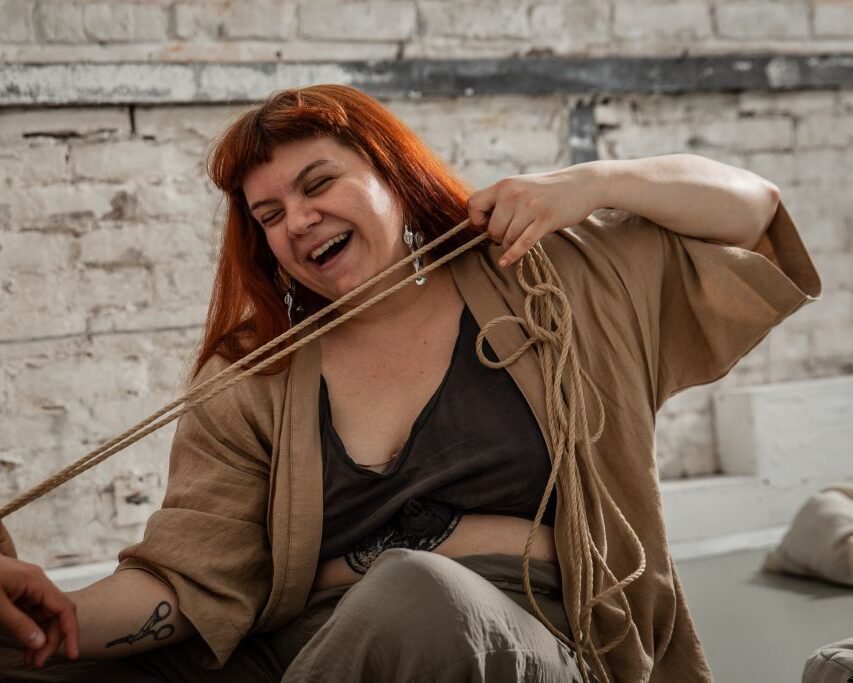 Woman laughing with rope indoors