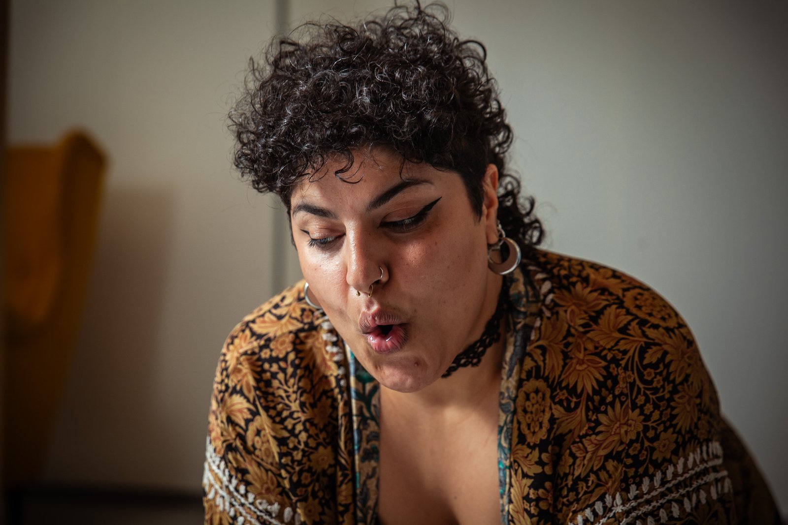 Person wearing patterned shawl and large earrings.