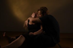 Couple embracing intimately in low warm lighting