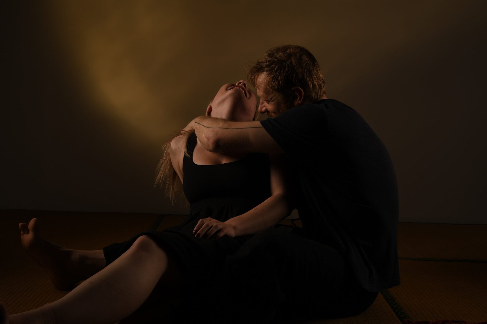 Couple embracing intimately in low warm lighting