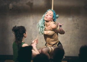 Rope bondage performance on stage with two women