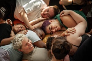 Group of friends lying together smiling indoors
