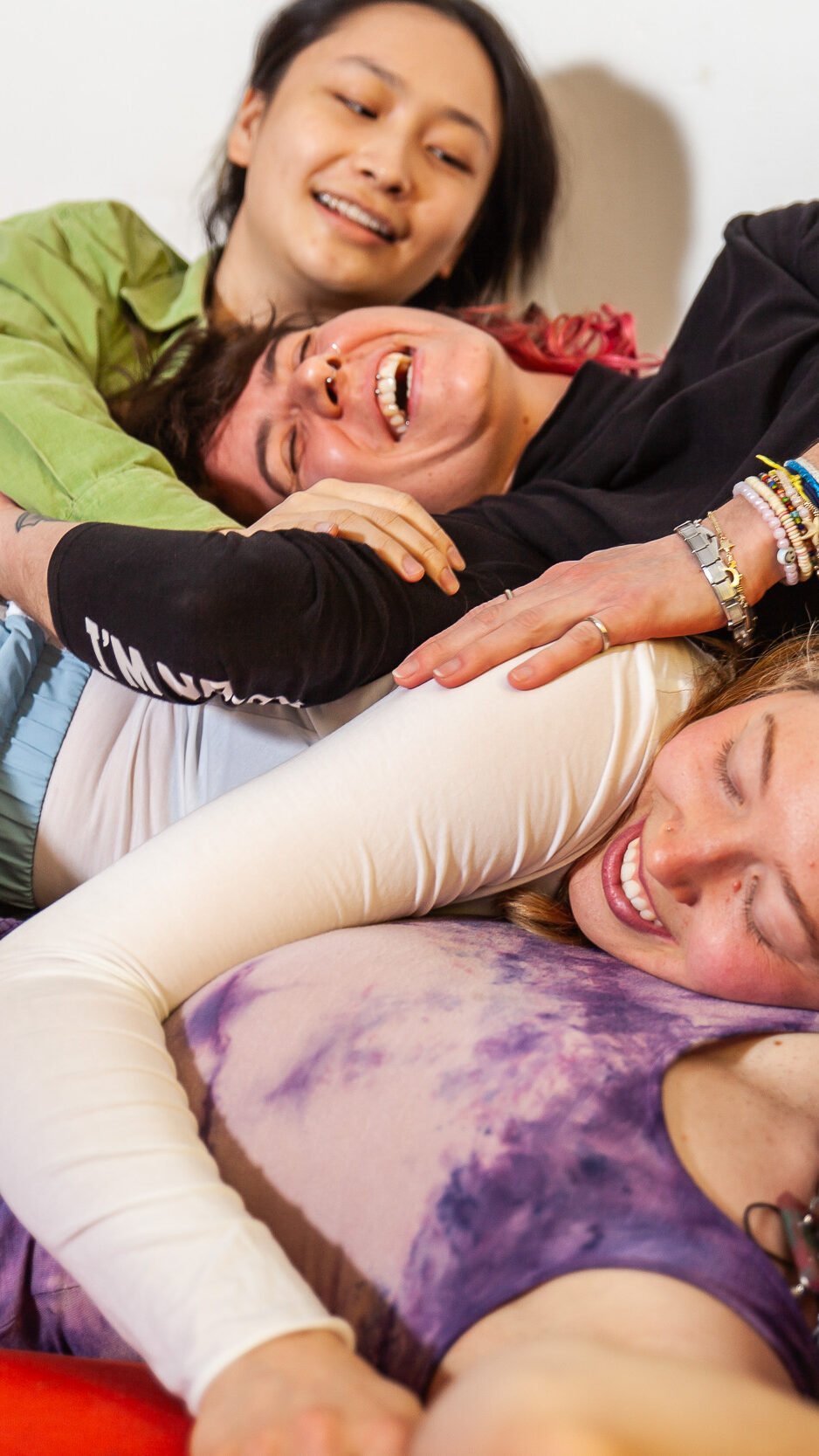Four friends in a playful group hug