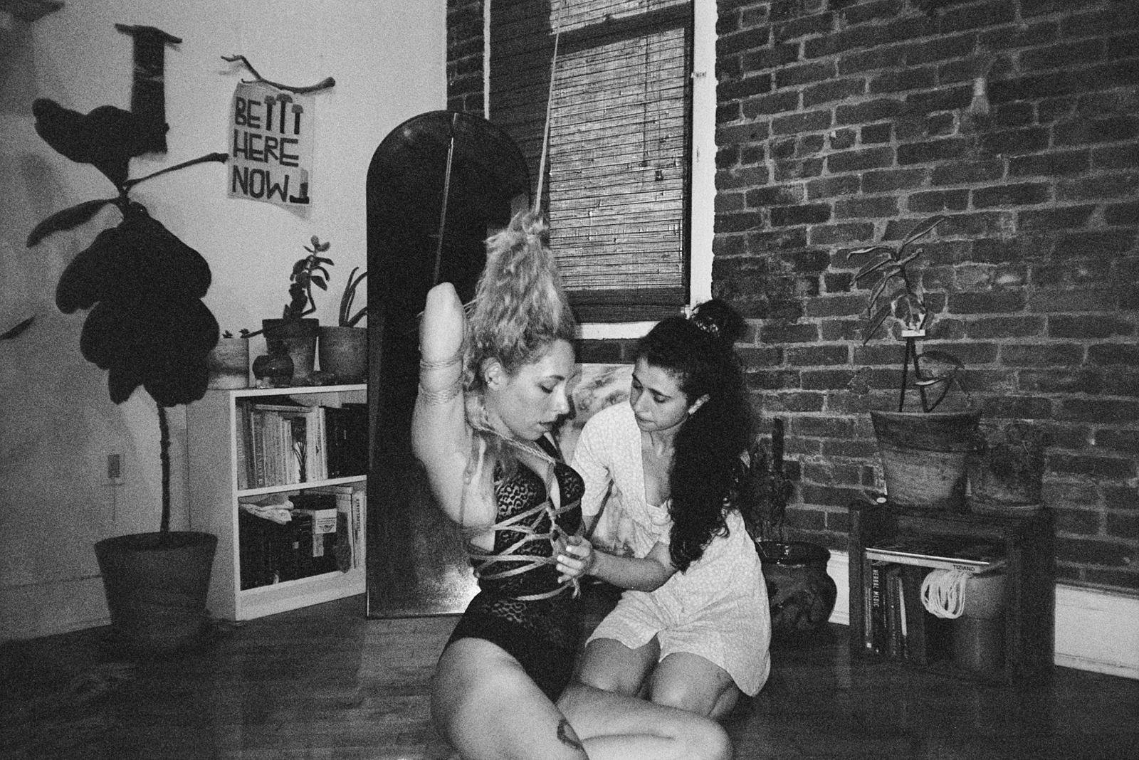breath play Two women practising rope bondage indoors
